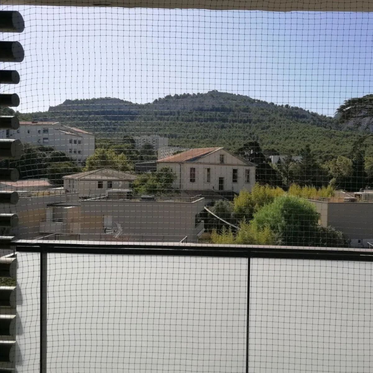 Grande terrasse protégée par un filet vert pour chat